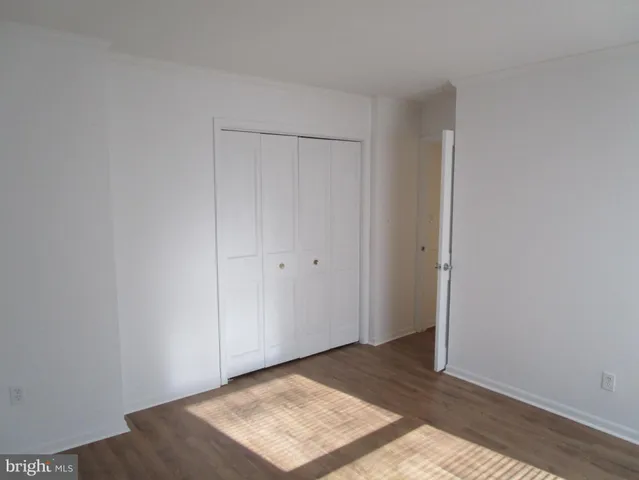 an empty room with wooden floor and a window