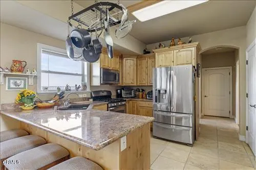 a kitchen with stainless steel appliances granite countertop a sink a stove and a refrigerator