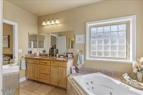 a spacious bathroom with a granite countertop tub a double vanity sink a window a mirror and vanity