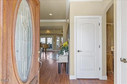 a view of a hallway with wooden floor and a dining room