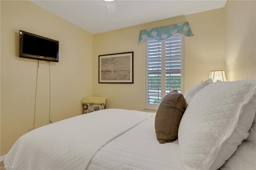 9281 Spring Run Boulevard, Unit 2607 Estero, FL 34135 - Photo 24 of 32 a bedroom with a bed a flat screen tv and a window