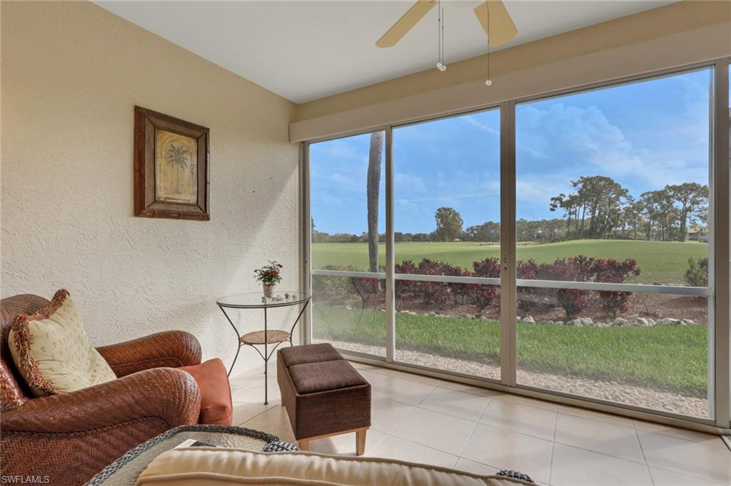 9281 Spring Run Boulevard, Unit 2607 Estero, FL 34135 - Photo 28 of 32 a living room with couch and a floor to ceiling window
