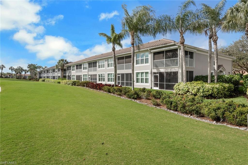 9281 Spring Run Boulevard, Unit 2607 Estero, FL 34135 - Photo 30 of 32 a view of a house with a big yard and palm trees