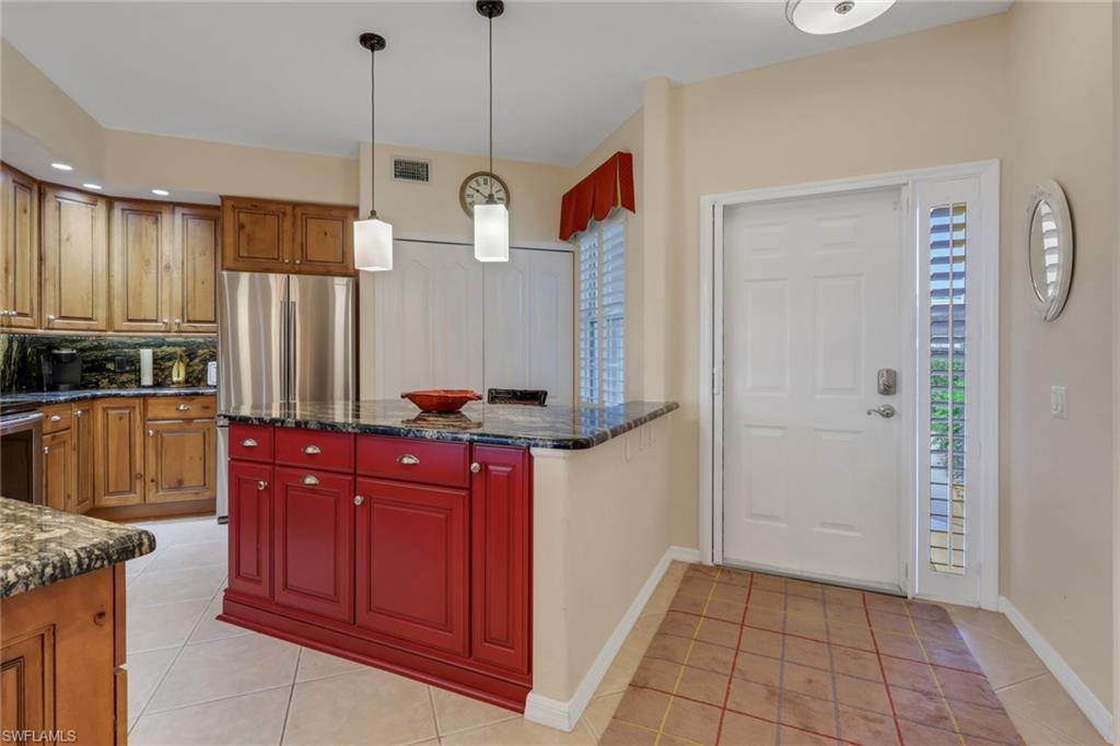 9281 Spring Run Boulevard, Unit 2607 Estero, FL 34135 - Photo 5 of 32 a kitchen with stainless steel appliances granite countertop a refrigerator a oven and a wooden cabinets