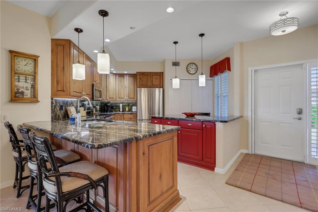 9281 Spring Run Boulevard, Unit 2607 Estero, FL 34135 - Photo 6 of 32 a kitchen with stainless steel appliances granite countertop a sink a stove and a refrigerator