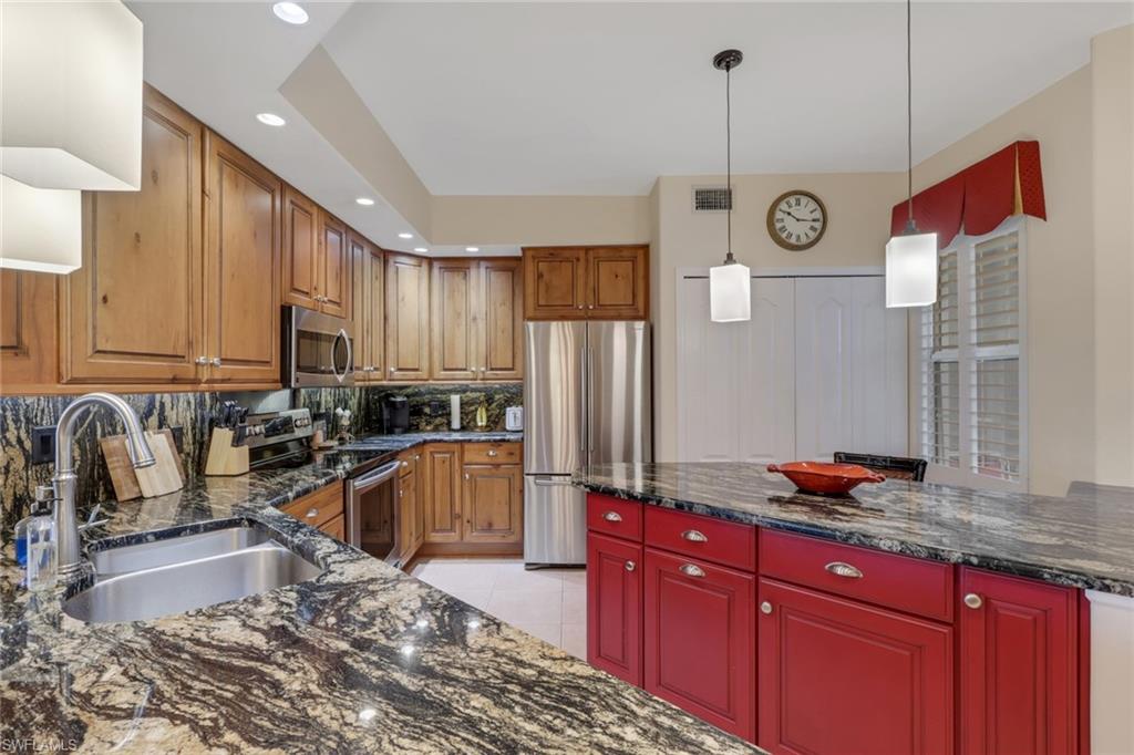 9281 Spring Run Boulevard, Unit 2607 Estero, FL 34135 - Photo 7 of 32 a kitchen with granite countertop a sink a counter top space appliances and cabinets
