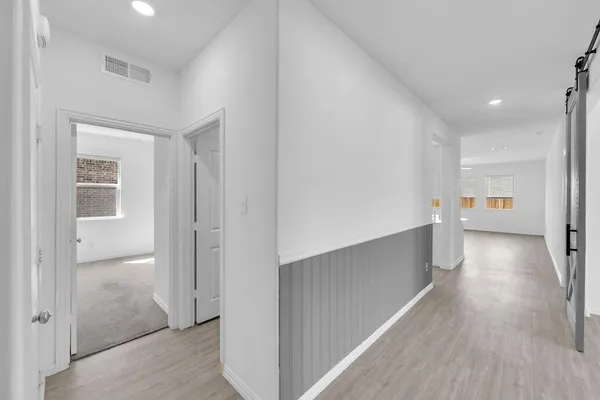 a view of a hallway with wooden floor