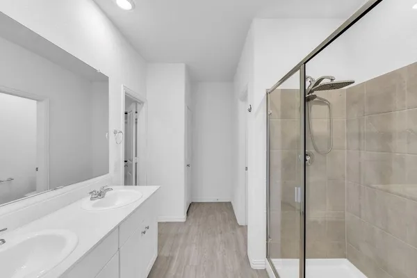 a bathroom with a double vanity sink and mirror with shower