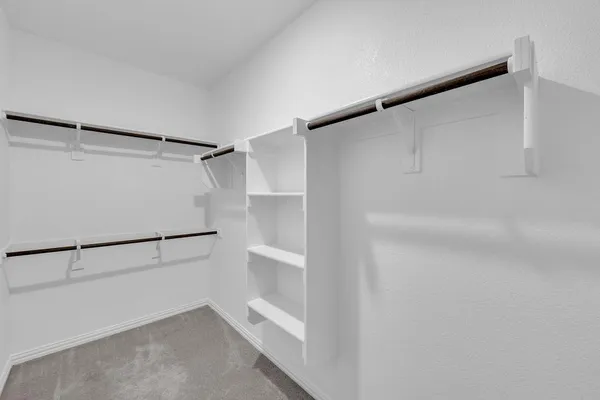 a view of walk in closet with empty racks