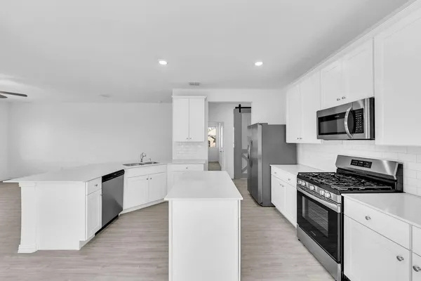 a kitchen with stainless steel appliances a refrigerator stove and microwave
