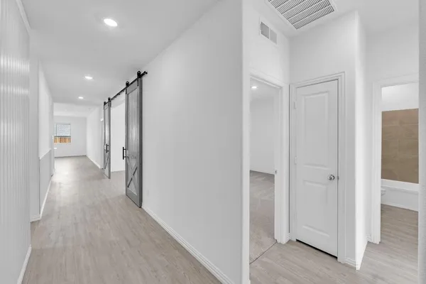 a view of a hallway with wooden floor