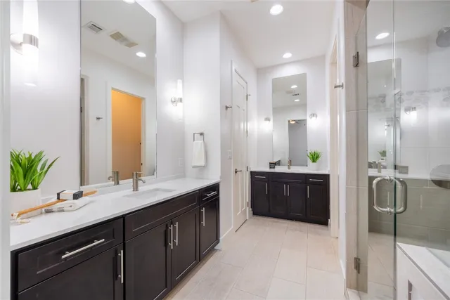 a bathroom with a double vanity sink mirror and shower