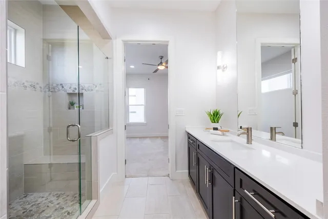 a bathroom with a double vanity sink mirror and shower