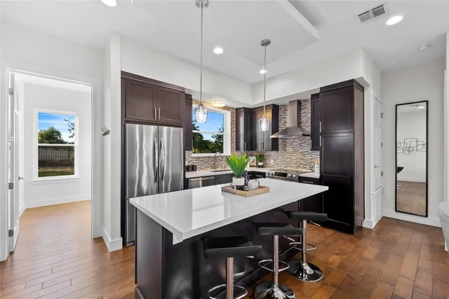 a kitchen with kitchen island a refrigerator stove and microwave