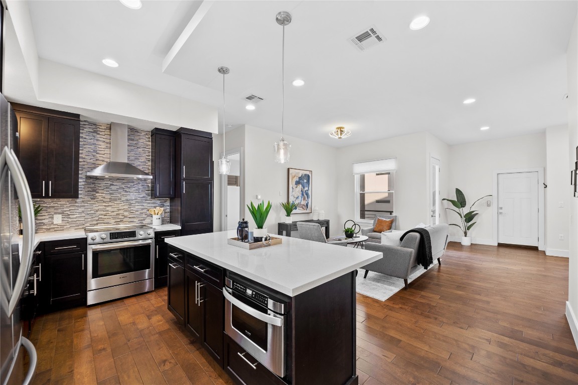 4300 Mansfield Dam Road, Unit 621 Austin, TX 78734 - Photo 5 of 34 a kitchen with stainless steel appliances granite countertop a stove top oven a sink dishwasher a refrigerator and a dining table with wooden floor
