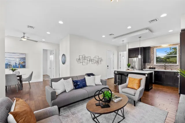 a living room with furniture kitchen view and a large window