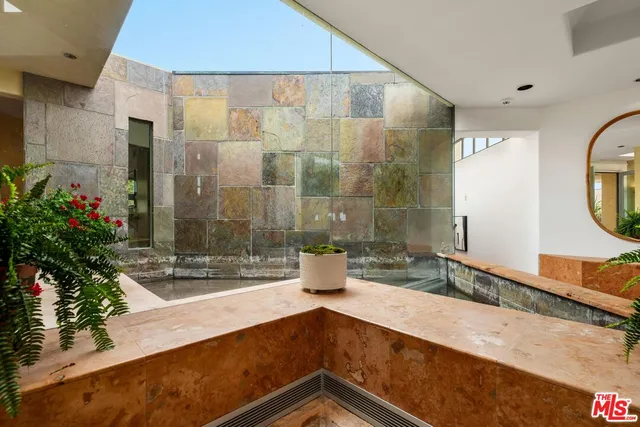 a view of a kitchen with kitchen island granite countertop a stove a sink and a refrigerator