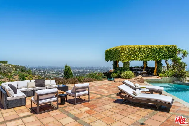 a view of a house with pool and sitting area