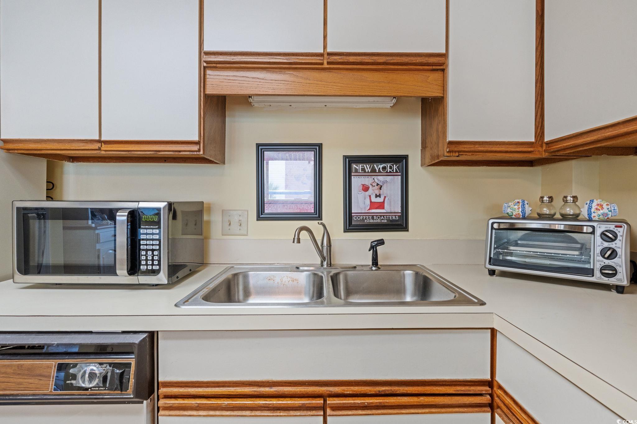 5511 North Ocean Boulevard, Unit 208 Myrtle Beach, SC 29577 - Photo 17 of 37 Kitchen featuring light countertops, white cabinets, and stainless steel microwave