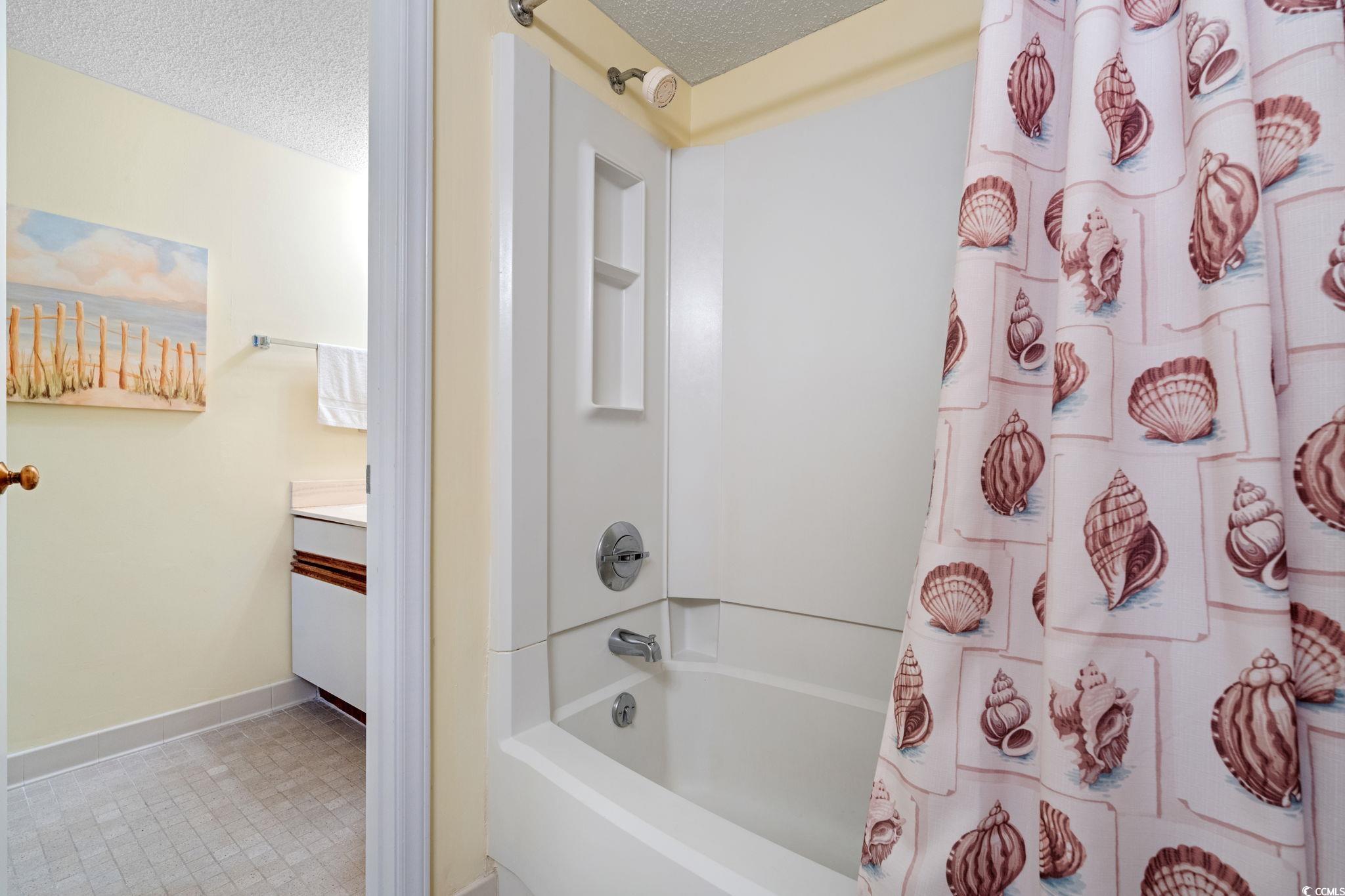5511 North Ocean Boulevard, Unit 208 Myrtle Beach, SC 29577 - Photo 19 of 37 Bathroom with vanity, tile patterned flooring, a shower with curtain, and a textured ceiling