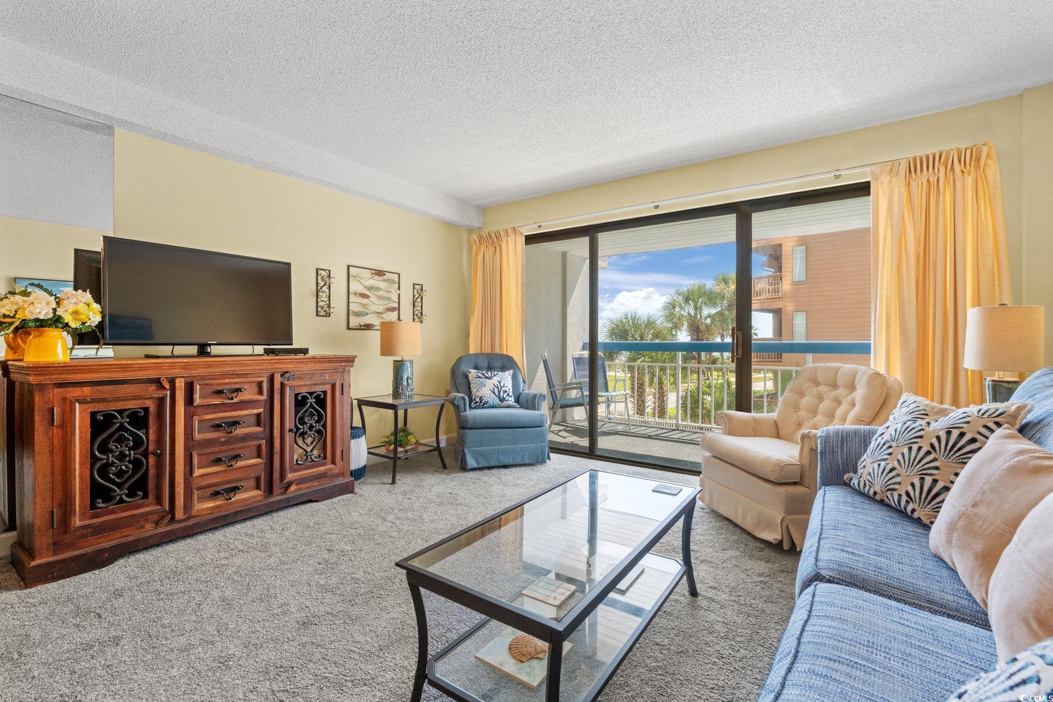 5511 North Ocean Boulevard, Unit 208 Myrtle Beach, SC 29577 - Photo 6 of 37 Carpeted living area with a textured ceiling