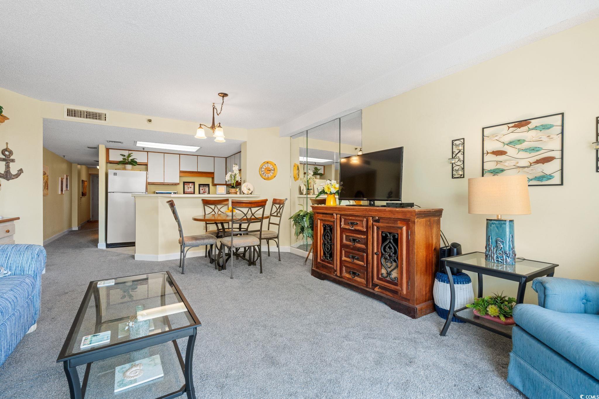5511 North Ocean Boulevard, Unit 208 Myrtle Beach, SC 29577 - Photo 8 of 37 Living room with light colored carpet and a chandelier