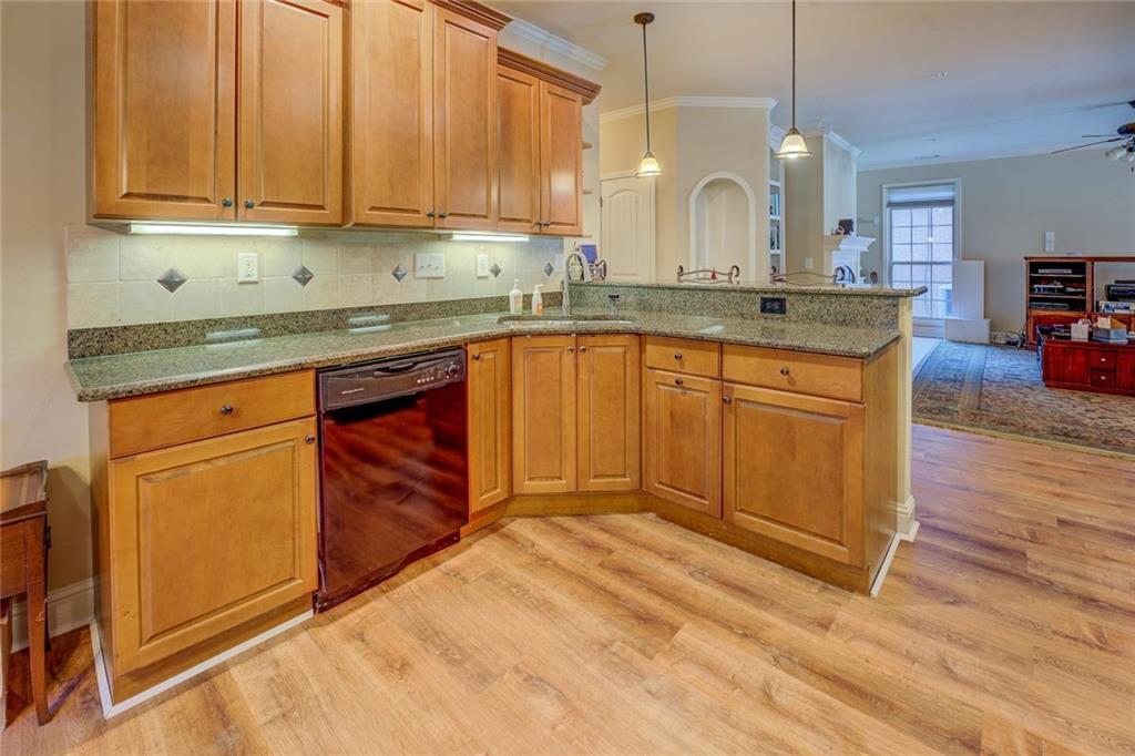 10155 Malcolm Drive Covington, GA 30014 - Photo 13 of 32 a kitchen with stainless steel appliances granite countertop a sink a stove cabinets and wooden floor
