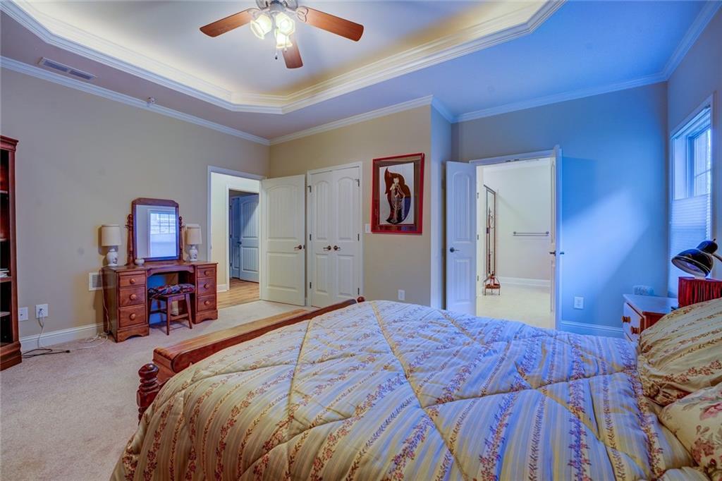 10155 Malcolm Drive Covington, GA 30014 - Photo 25 of 32 a bedroom with a large bed and a chandelier