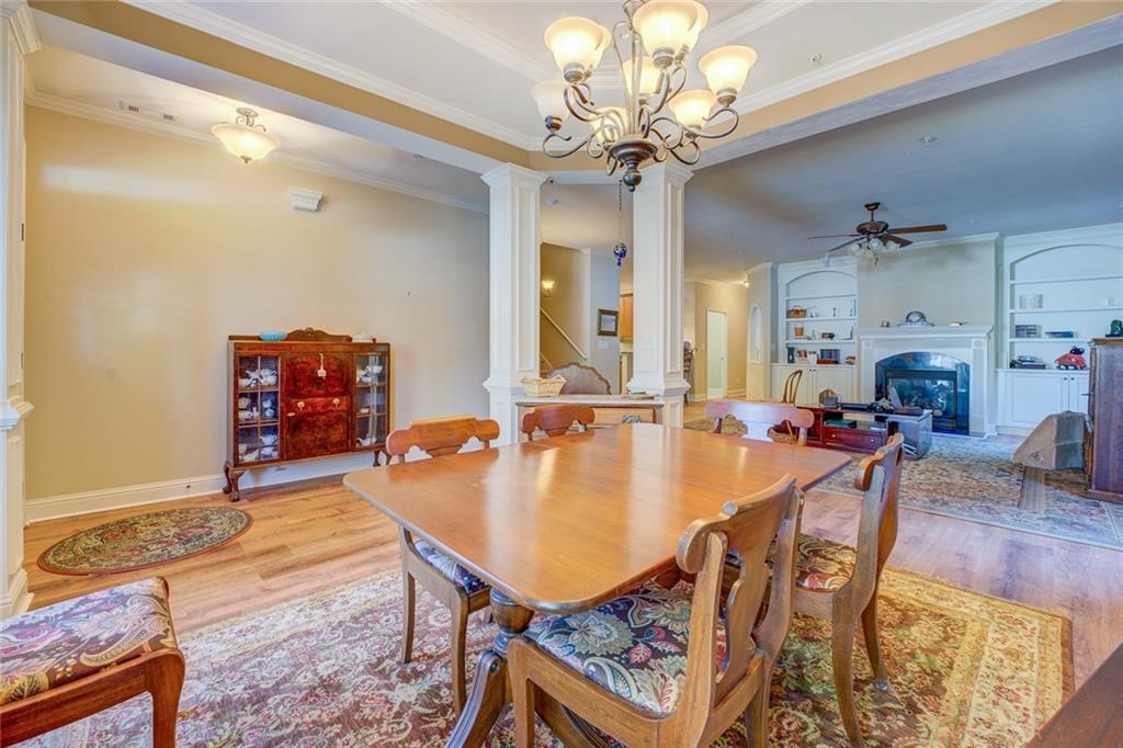 10155 Malcolm Drive Covington, GA 30014 - Photo 3 of 32 a dining room with wooden floor a chandelier a wooden table and chairs