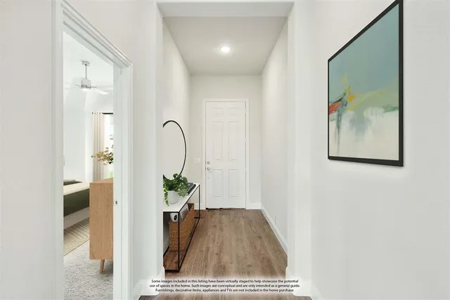a view of a hallway with wooden floor and a potted plant