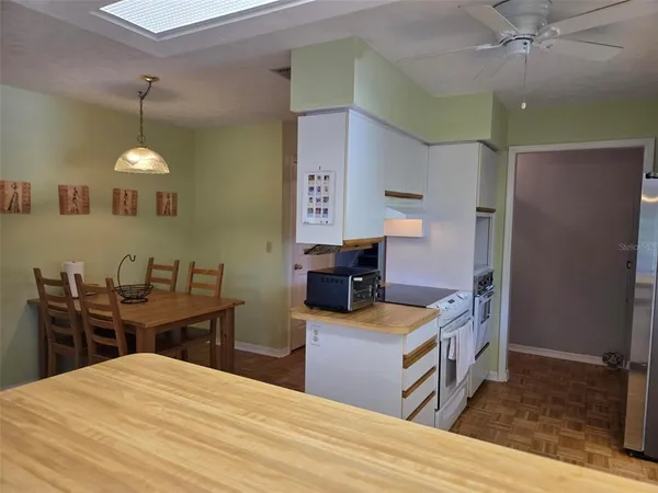 a kitchen that has a sink a stove counter space and wooden floor