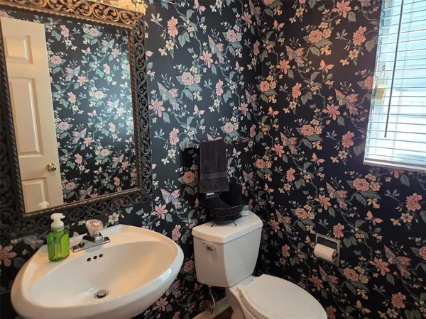 a bathroom with a sink mirror and toilet