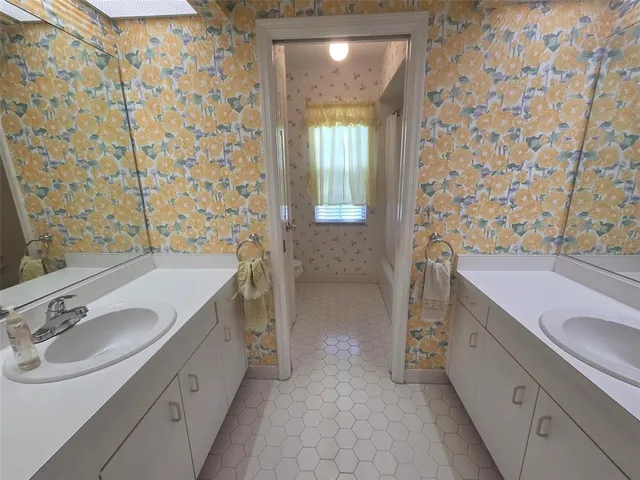 a spacious bathroom with a granite countertop sink a toilet a mirror and shower