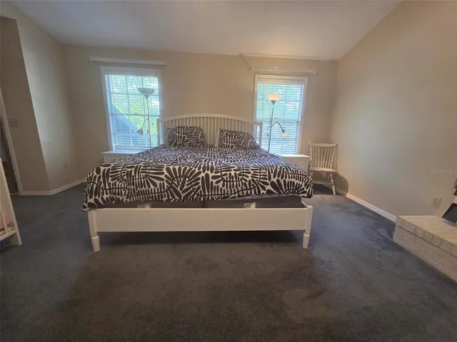 a large bed sitting in a bedroom next to a window