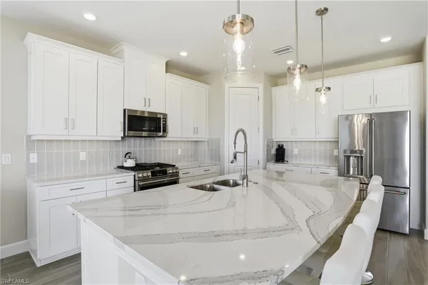 a view of a kitchen counter space a sink wooden floor and a window