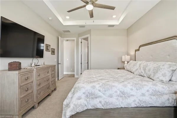 a bedroom with a bed and a flat tv screen on dresser