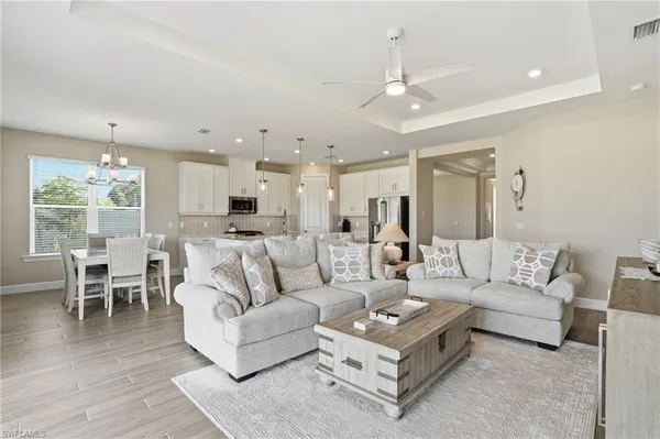 a living room with furniture and a large window with kitchen view