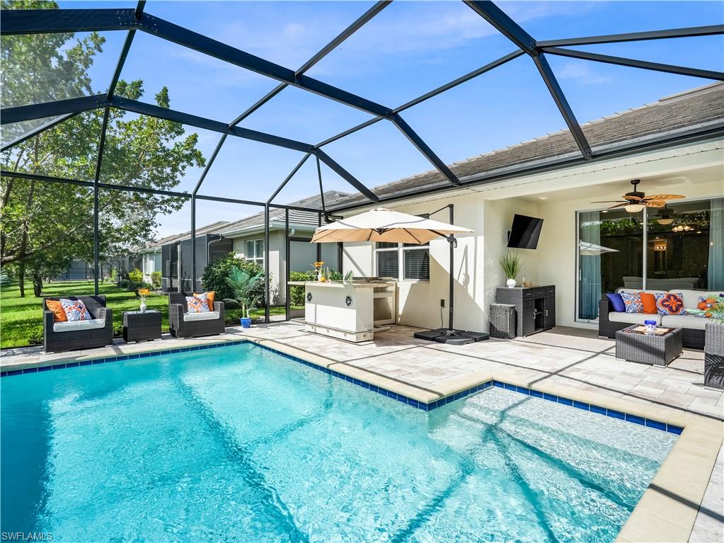 14695 Edgewater Circle Naples, FL 34114 - Photo 26 of 39 a view of pool with lawn chairs and a umbrella
