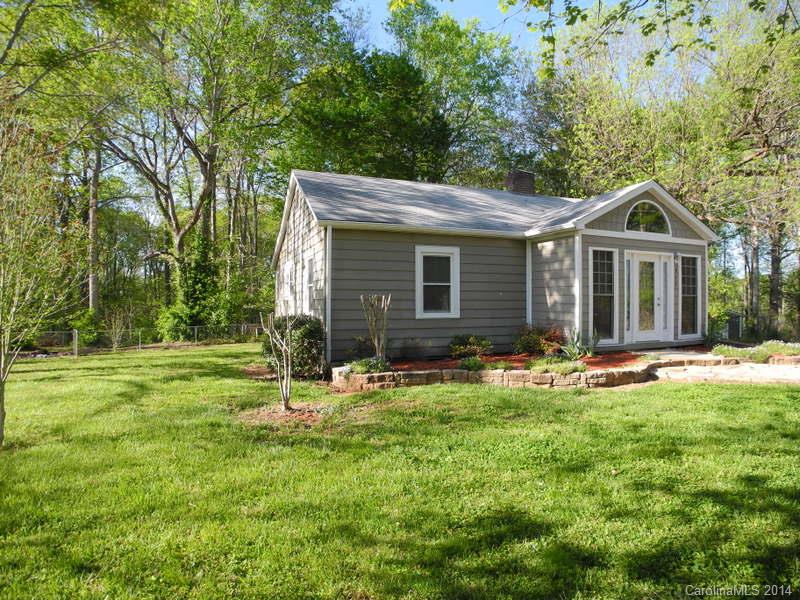 617 Blacksnake Road Stanley, NC 28164 - Photo 3 of 24 a backyard of a house with table and chairs and wooden fence