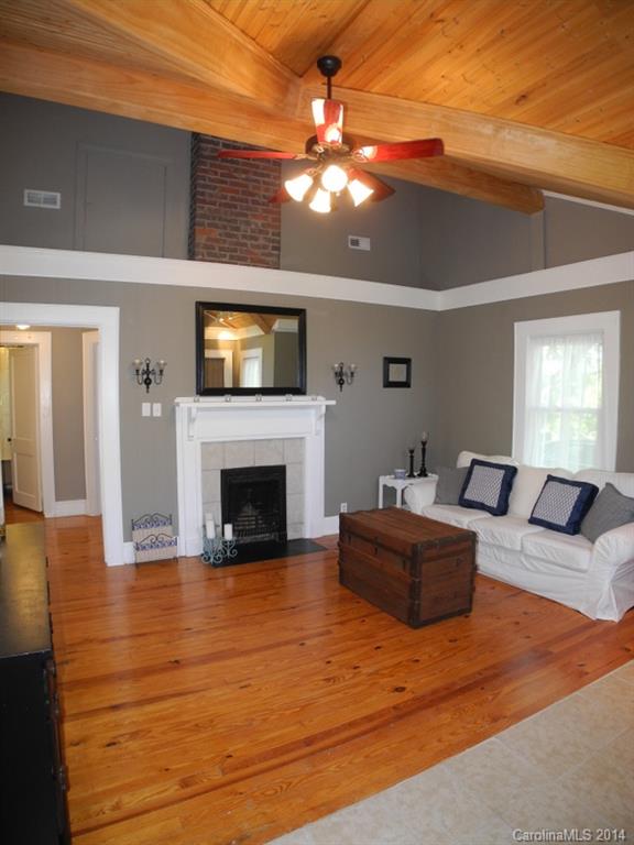 617 Blacksnake Road Stanley, NC 28164 - Photo 9 of 24 a living room with furniture a fireplace and a flat screen tv