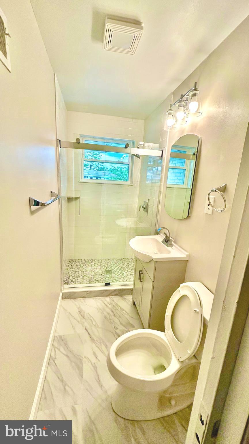 5319 Pooks Hill Road, Unit 1 Bethesda, MD 20814 - Photo 24 of 37 a bathroom with a sink mirror vanity and toilet