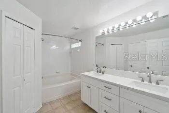 a bathroom with a sink a toilet a mirror and shower