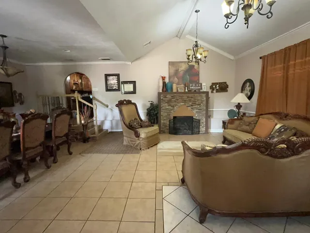 a living room with furniture a light fixture and a flat screen tv
