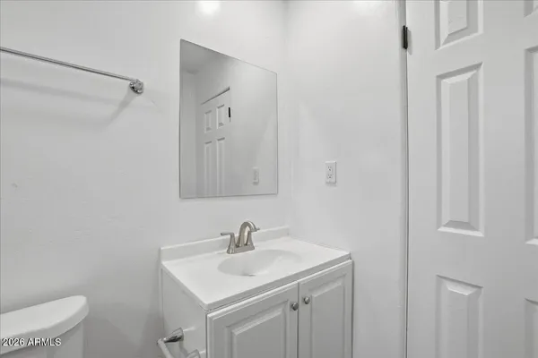 an empty room with wooden floor cabinet and windows