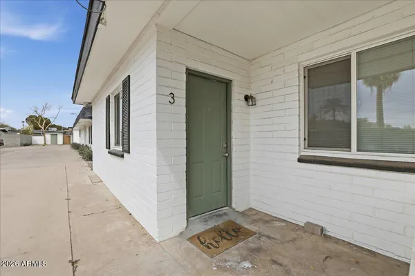an empty room with wooden floor cabinet and windows