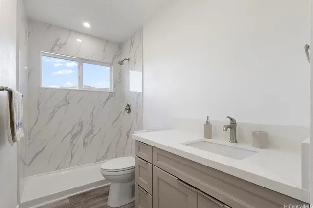 a bathroom with a sink a toilet and shower