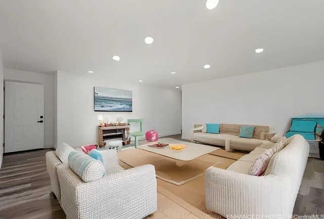 a living room with furniture and a wooden floor