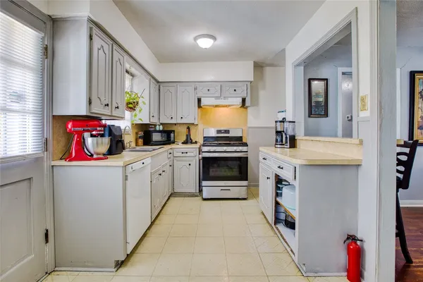 a kitchen with a sink stove and cabinets