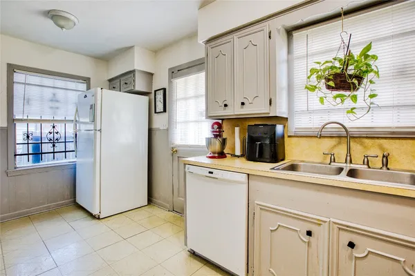 a kitchen with stainless steel appliances a refrigerator sink and white cabinets