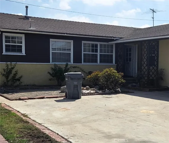 a view of a house with potted plants and a garage